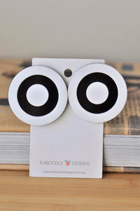 Two black and white target circle stud earrings on a Kaboodle Designs card, front view