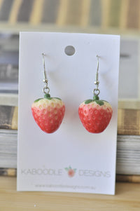 Pair of resin strawberry drop earrings on a Kaboodle Designs display card