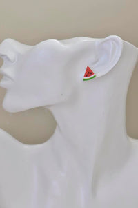 Watermelon slice stud earring shown worn on ear for scale