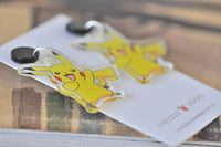 Close-up angled view of yellow cartoon mouse earrings resting on Kaboodle Designs card
