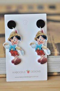 Pair of Pinocchio glitter dangle earrings on a white display card with black studs