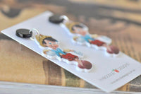 Close-up of Pinocchio earrings showing glitter cap and red shorts detail