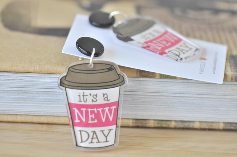Close-up of a single coffee cup dangle earring showing the black stud top and printed design