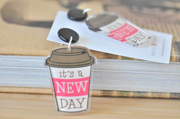 Close-up of a single coffee cup dangle earring showing the black stud top and printed design