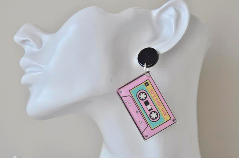 Cassette tape dangle earring worn on a model's ear, showing the black top and hanging cassette charm
