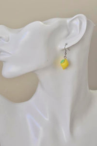 Single lemon earring worn on ear, close-up side view