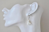Puppy dangle earring worn on a model ear, side profile close-up