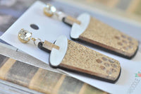 Close-up angled view of glitter bubble tea earrings showing straw and tapioca pearl cut-outs