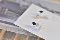 Close-up of astronaut earring backs showing zinc alloy fittings and enamel finish