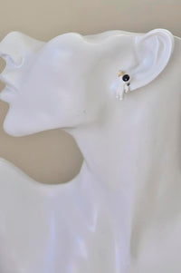 Astronaut star stud earring worn on ear, close-up side view