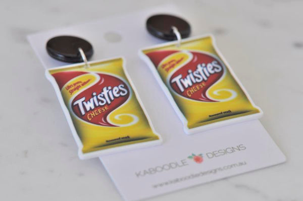 Close-up of Twisties Cheese packet earrings showing glossy printed detail and black stud tops