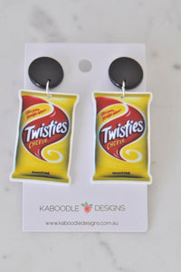 Pair of Twisties Cheese packet drop earrings with black round studs on a Kaboodle Designs card