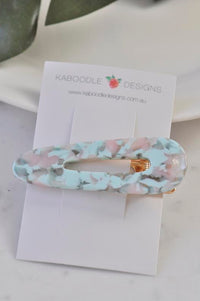 Teal and pink swirl barrette displayed on Kaboodle Designs branded card