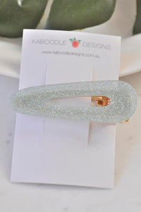 Silver glitter barrette clip laid flat on a Kaboodle Designs branded card