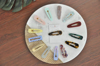 Full range of Kaboodle acrylic barrette clips in assorted colours arranged in a circle