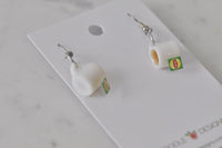 Pair of teacup dangle earrings shown on display card, one front-facing and one side view