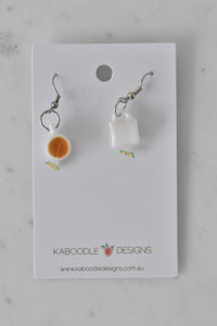 Teacup earrings laid flat on Kaboodle Designs branded card showing both angles