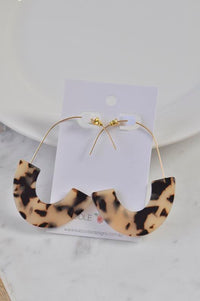 Tortoiseshell-leopard print acrylic hoop earrings on a white card against a plate background