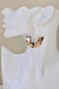 Close-up of leopard print acrylic hoop earring worn on a display ear model