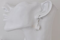 Teacup earring worn on ear, shown from behind against a white ceramic bust