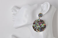 Close-up on model showing scale of large glitter star circle earring