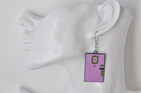 Close-up of purple door earring with peephole frame, shown on ear