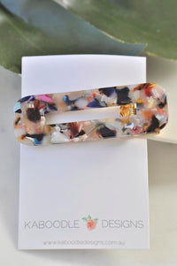 Speckled acrylic rectangular barrette displayed on Kaboodle Designs branded card