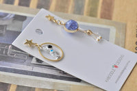 Astronaut and galaxy earrings displayed on card next to Kaboodle Designs branding
