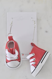 Pair of red fabric sneaker drop earrings with white laces on jewellery card