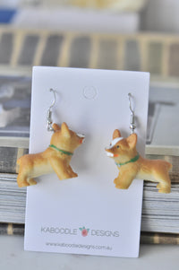 Pair of resin corgi dog drop earrings on Kaboodle Designs display card