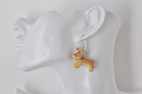 Single corgi earring worn on ear against white ear display
