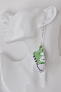 Green version of the sneaker earring shown worn on an ear for scale