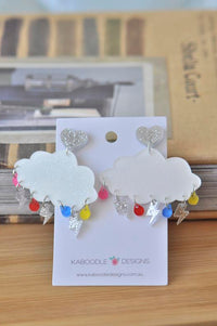 White glitter cloud earrings with silver lightning bolts and rainbow raindrops on Kaboodle Designs card