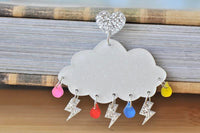 Single glitter cloud earring with heart stud, silver lightning bolts and coloured raindrops on book