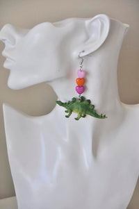 Stegosaurus heart earring worn on a display bust, close-up side view
