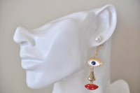 Side view of face earring on ear showing pearl stud, gold eye and dangling red lips
