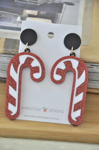 Two glittery red and white candy cane perspex drop earrings on Kaboodle Designs card