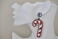 Candy cane drop earring shown worn on ear for scale, hanging from black stud top