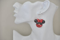 Polka dot bow mouse ears donut earring shown on ear for scale