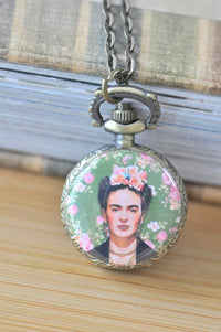Bronze pocket watch necklace with Frida Kahlo portrait on green floral background