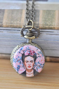 Bronze pocket watch necklace with Frida Kahlo portrait on pastel pink floral background