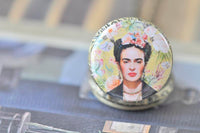 Close-up of the Frida Kahlo pocket watch pendant with pastel floral artwork