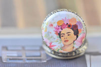 Close-up of Frida Kahlo pocket watch necklace pendant showing detailed floral crown artwork