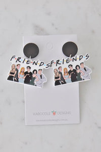 Acrylic Friends TV show earrings on card with black stud tops, cast illustration and logo