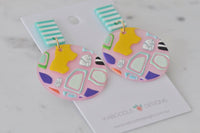 Close-up of two geometric pattern resin earrings on Kaboodle Designs card