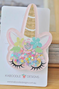Pink acrylic unicorn face brooch with gold glitter horn and floral ears on card