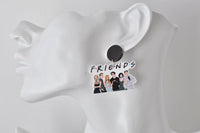 Close-up of Friends earring worn on ear showing black stud and cast artwork