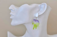 Green and purple brush drop earring shown worn on ear, close-up angle