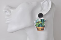 Free Hugs cactus earring worn on ear, shown from the side for scale