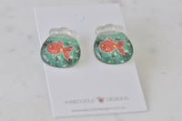 Angled view of goldfish bowl earrings showing glossy resin finish and stud backs
